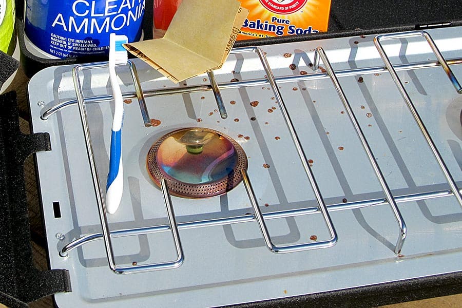 Camp stove with cleaning items in background