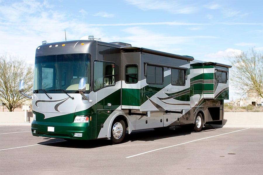 Green and grey motorhome in parking area
