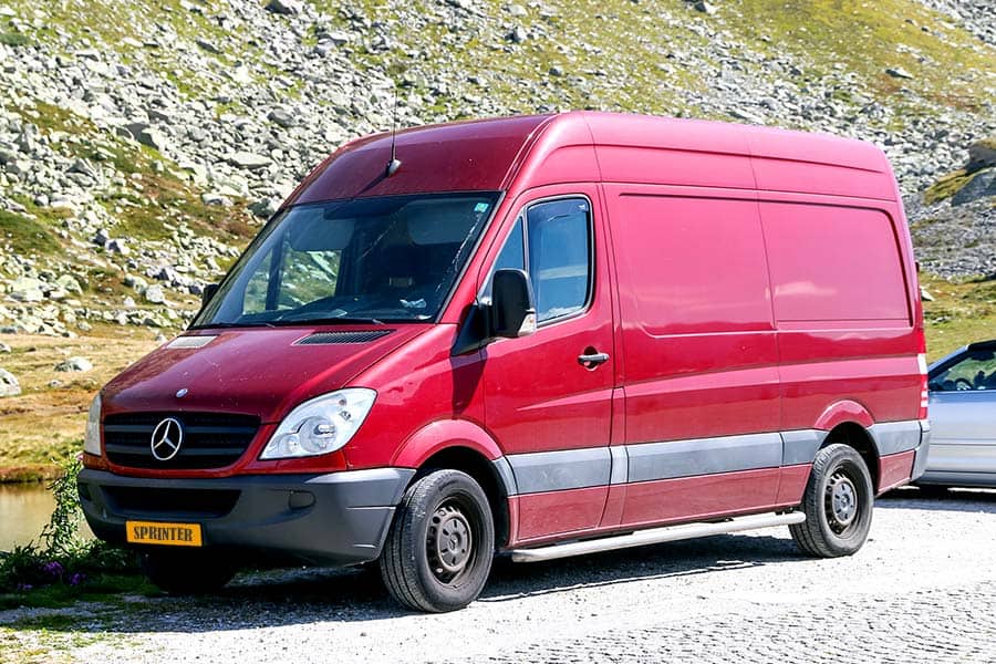 Red Sprinter van parked at edge of road