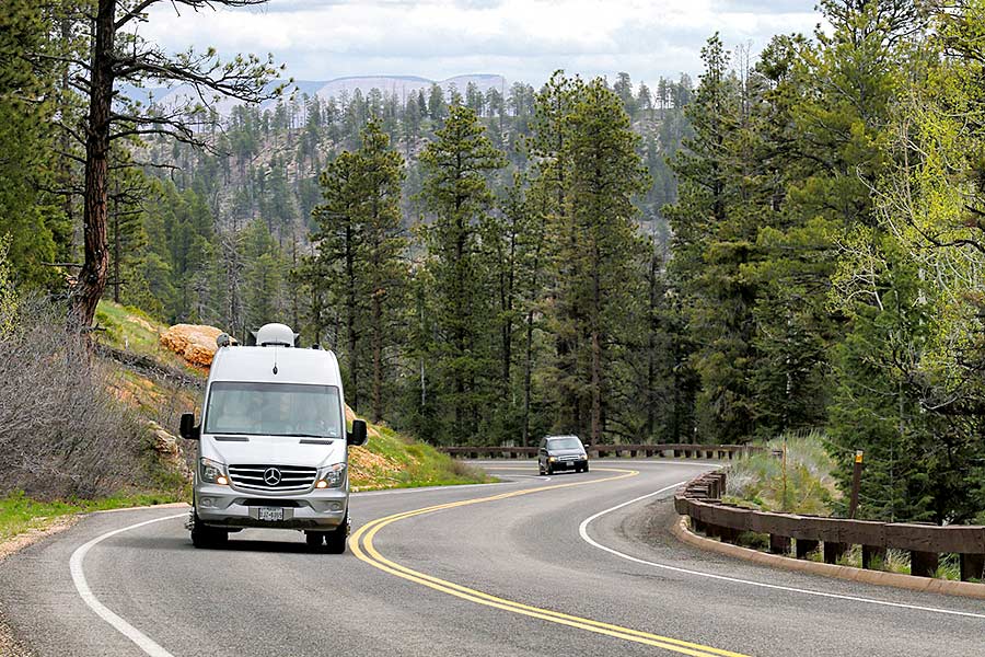 Camper van on highway through woods