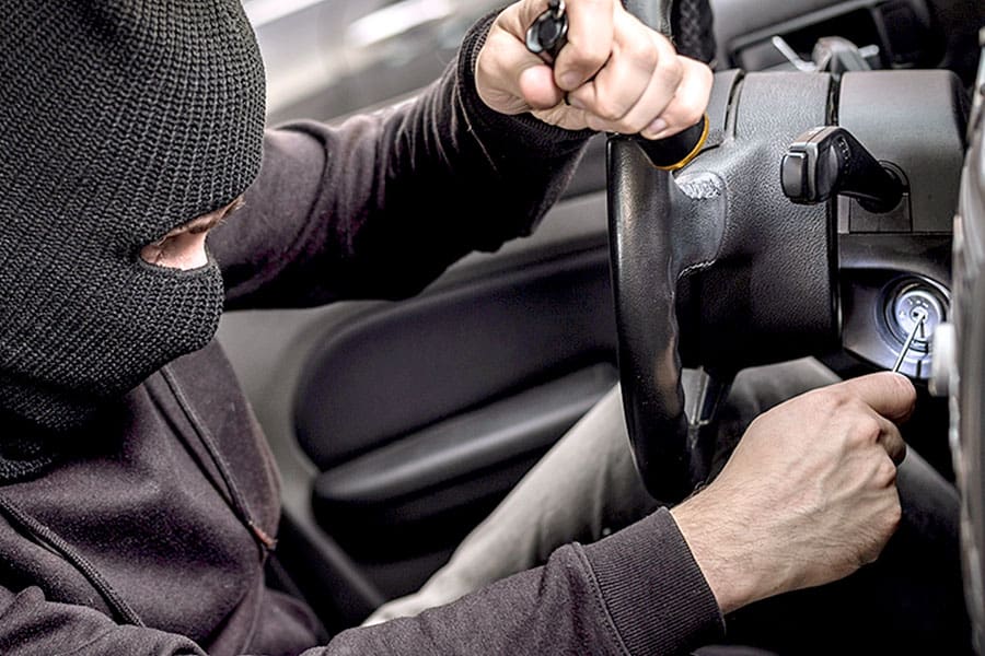 Thief dressed in black trying to start vehicle