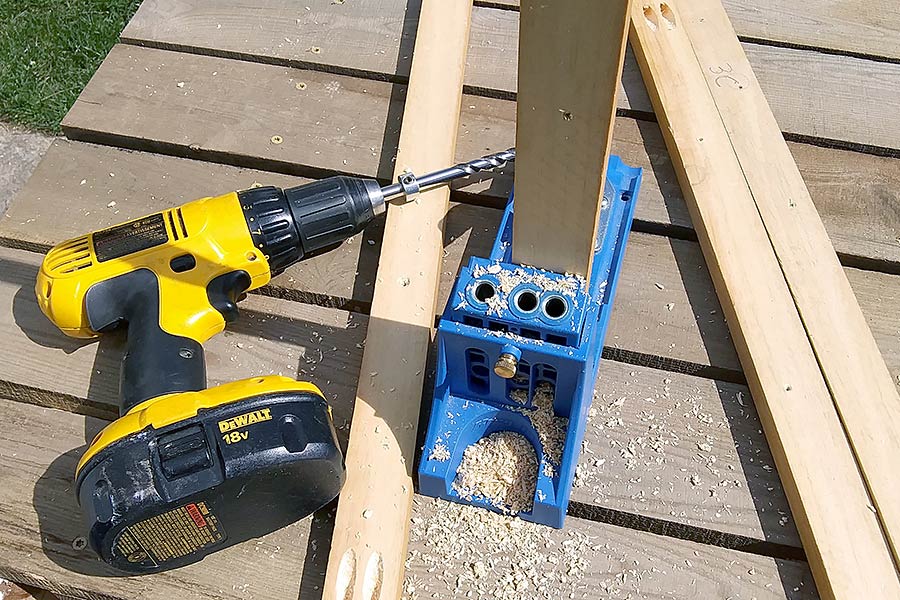 A blue Kreg tool and a cordless drill on a wooden table