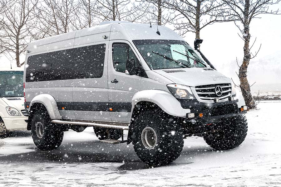 Mercedes Benz van with large tires in a snowstorm
