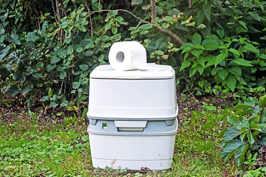 Portable toilet with toilet paper in an outdoor setting