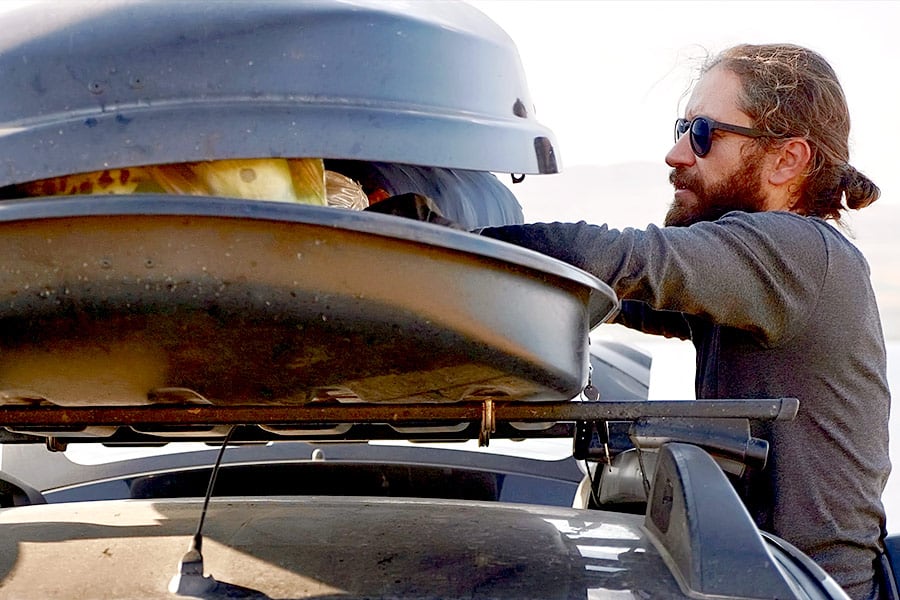 Man opening cargo box on vehicle roof