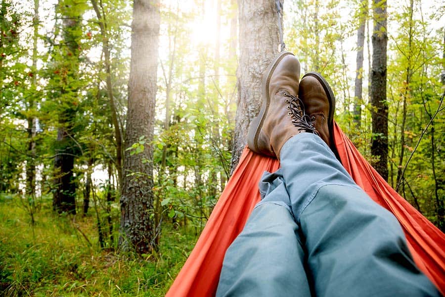 Looking at the feet of a man in a hammock in a forest setting