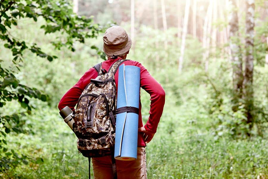 Hiker with a backpack walking in the woods