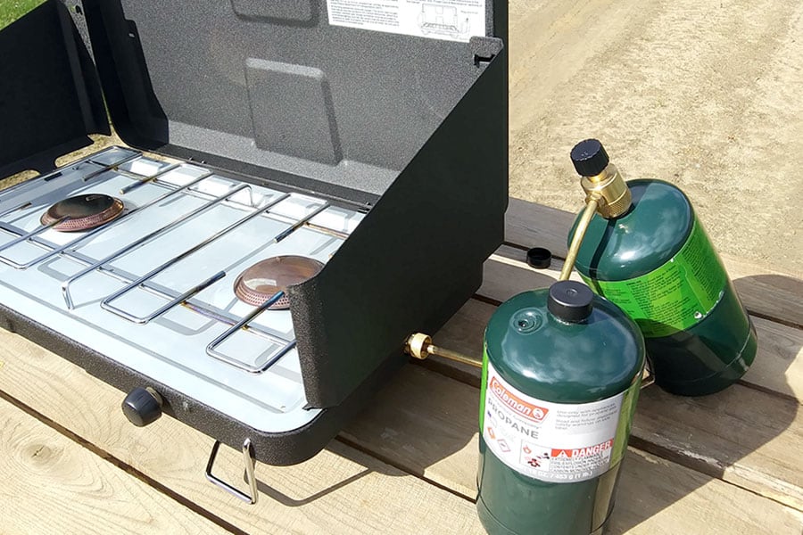 A camp stove with propane bottles on a table
