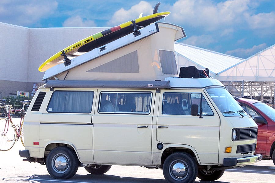 Cream colored VW van in a store parking lot