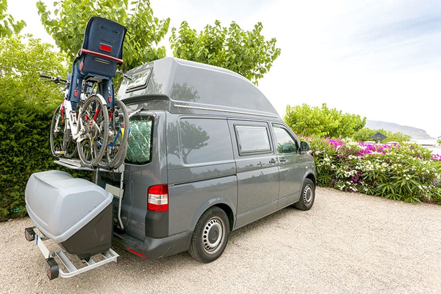 Gray van parked with bicycles and storage on back