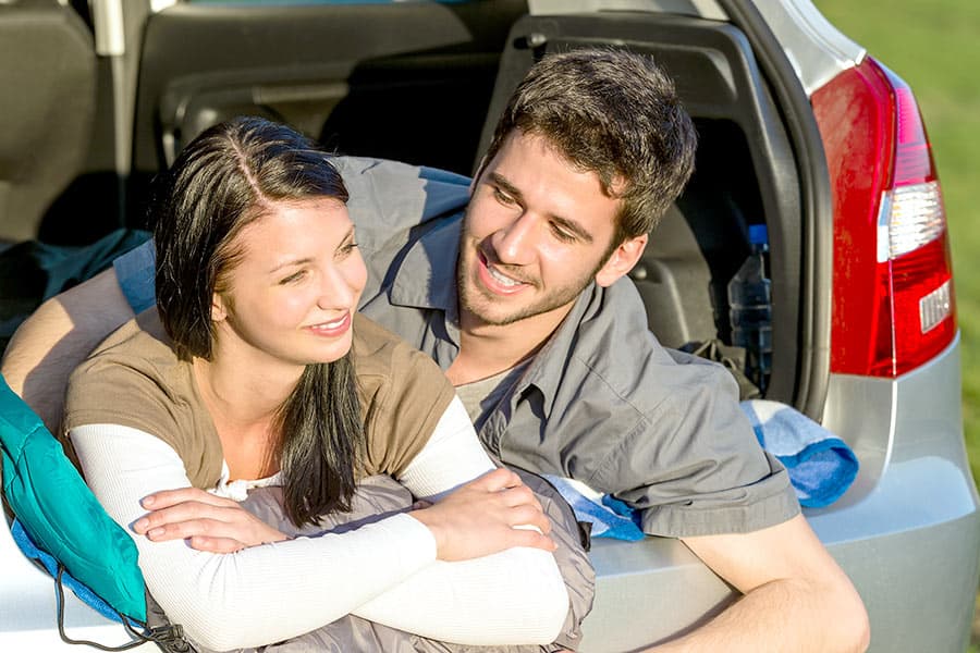 Man and woman laying in back of car