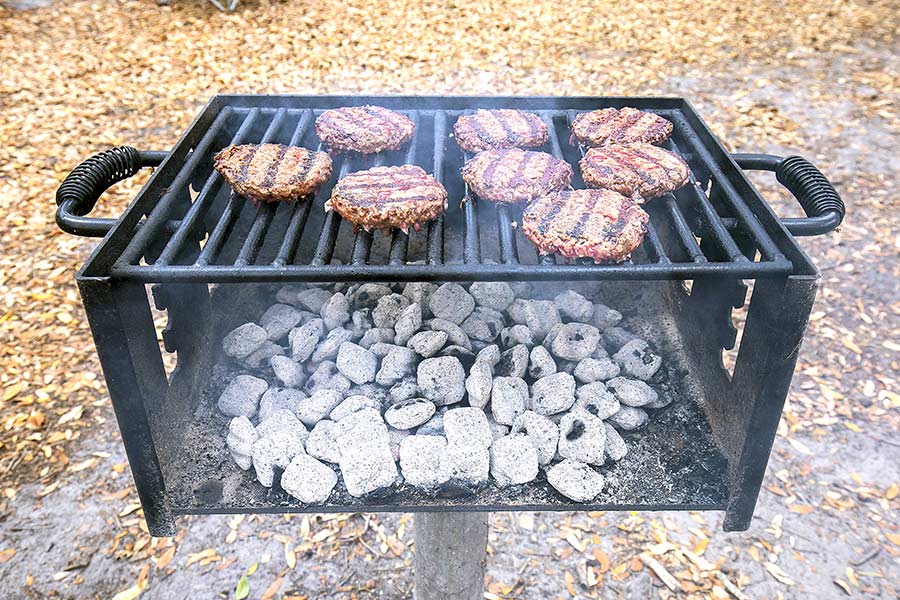 Hamburgers cooking on a public BBQ grill