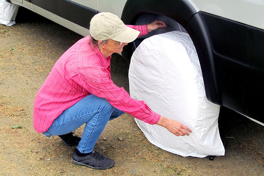 Woman installing tire covers on van