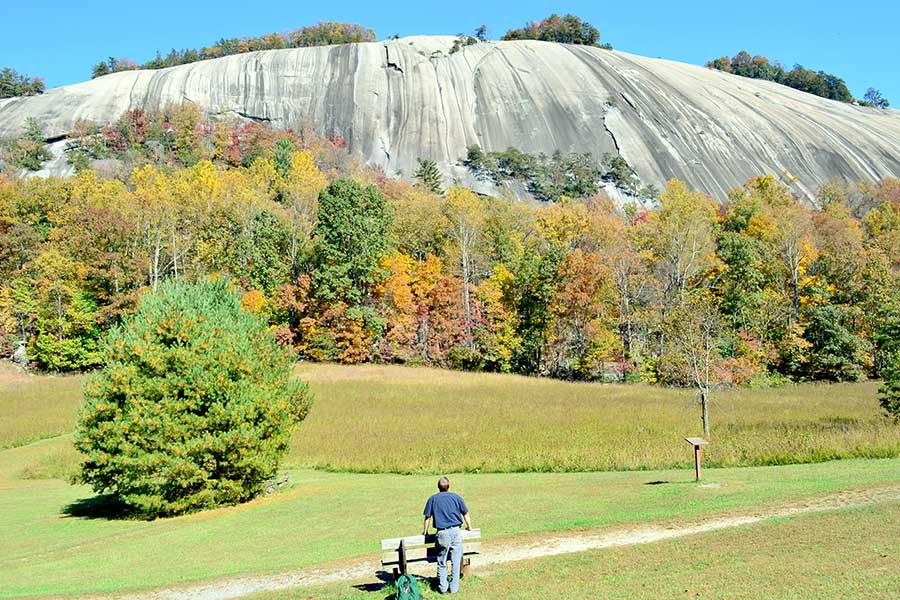 Man looking at quartz monzonite dome at Stone Mountain Park