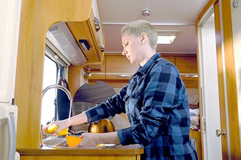 Woman washing dishes in van