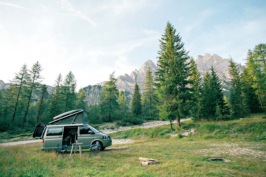 Pop top camper van parked in mountain meadow