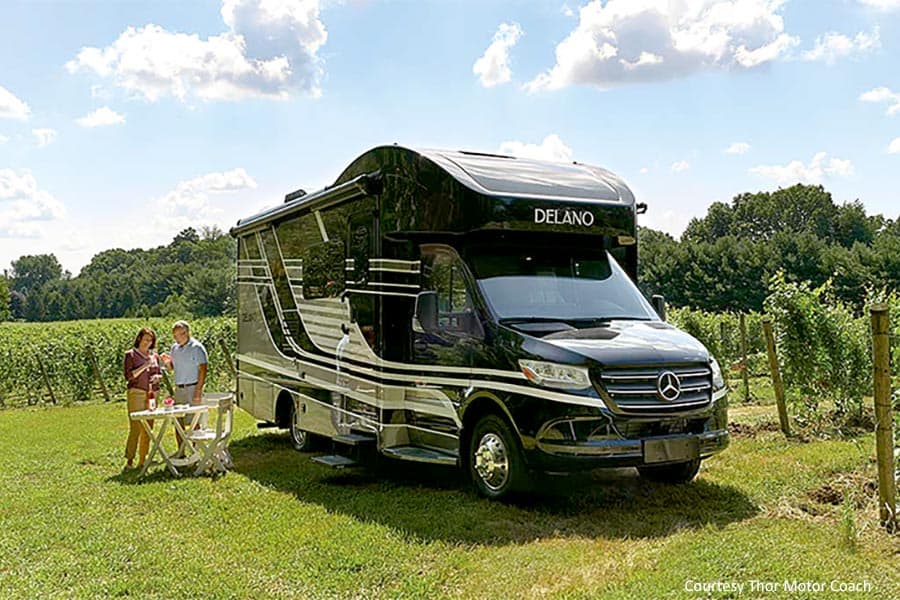 Couple eating lunch beside a Thor Motor Coach RV