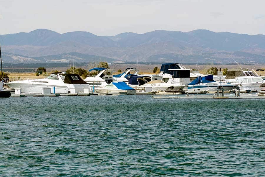 Boats docked at Pueblo Reservoir, mountains in background