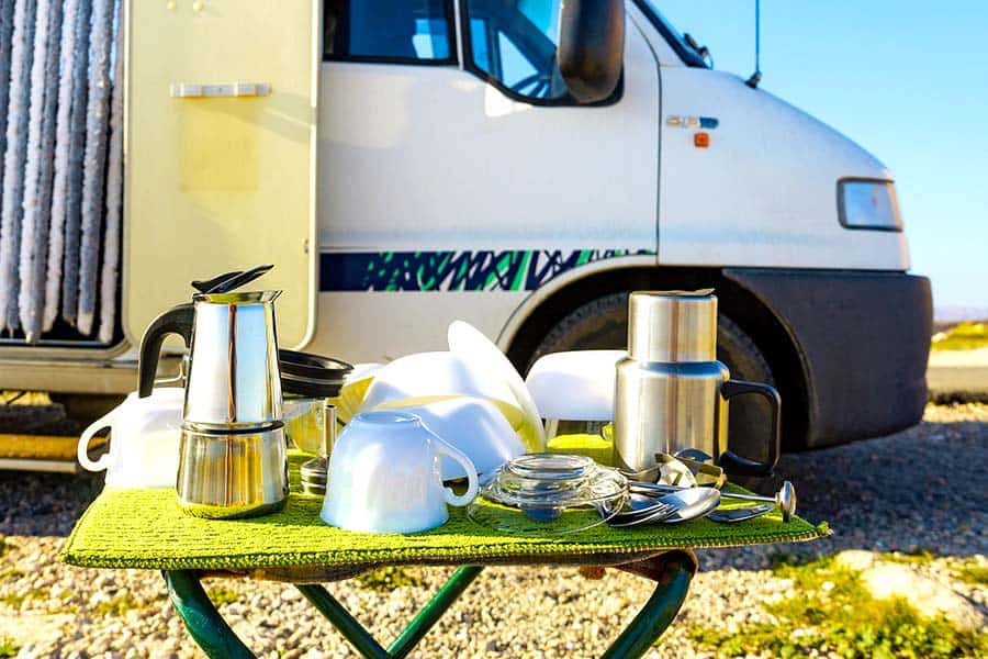 Dishes on portable table in front of parked RV