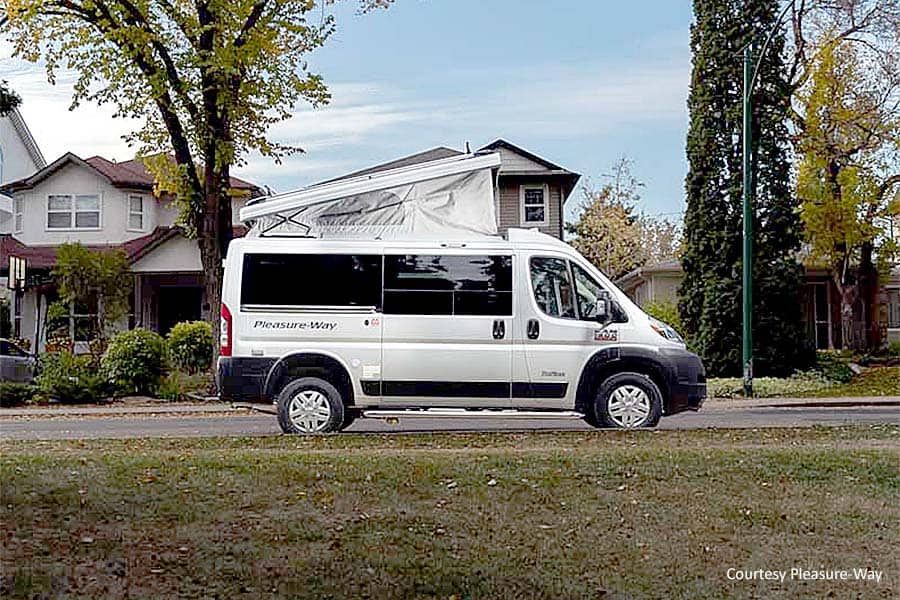 Class B with a pop up parked in front of houses