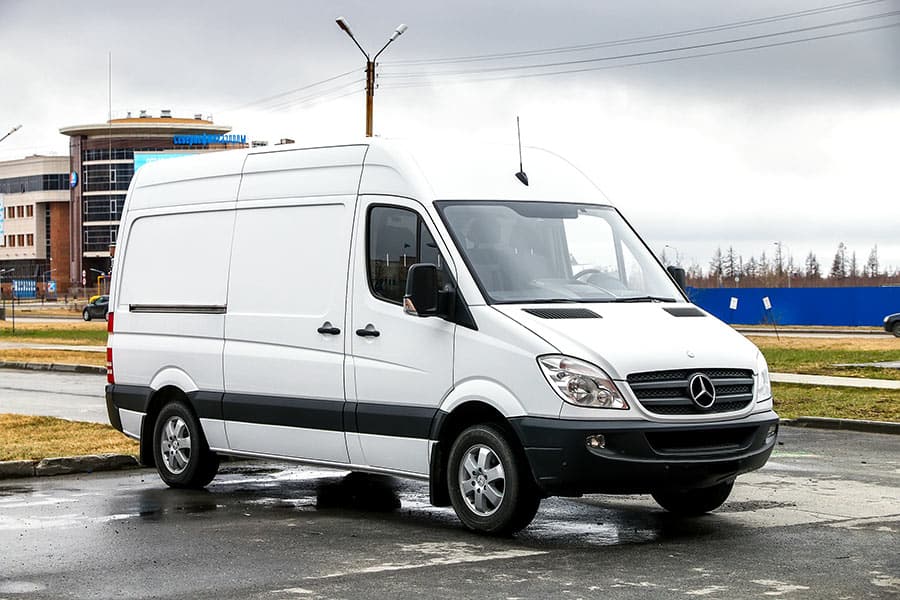 A white Mercedes-Benz Sprinter cargo van parked on blacktop