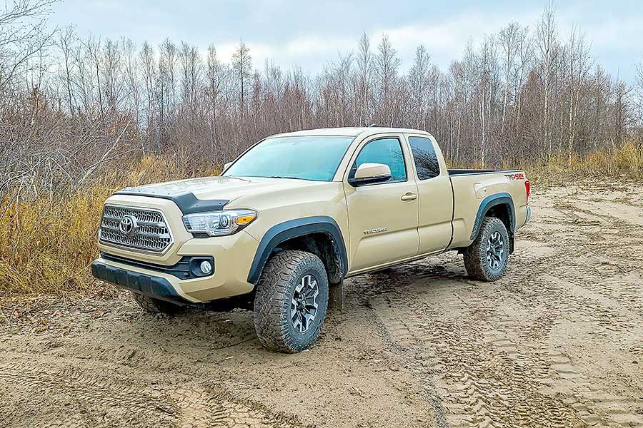 Cream colored Toyota truck parked on dirt