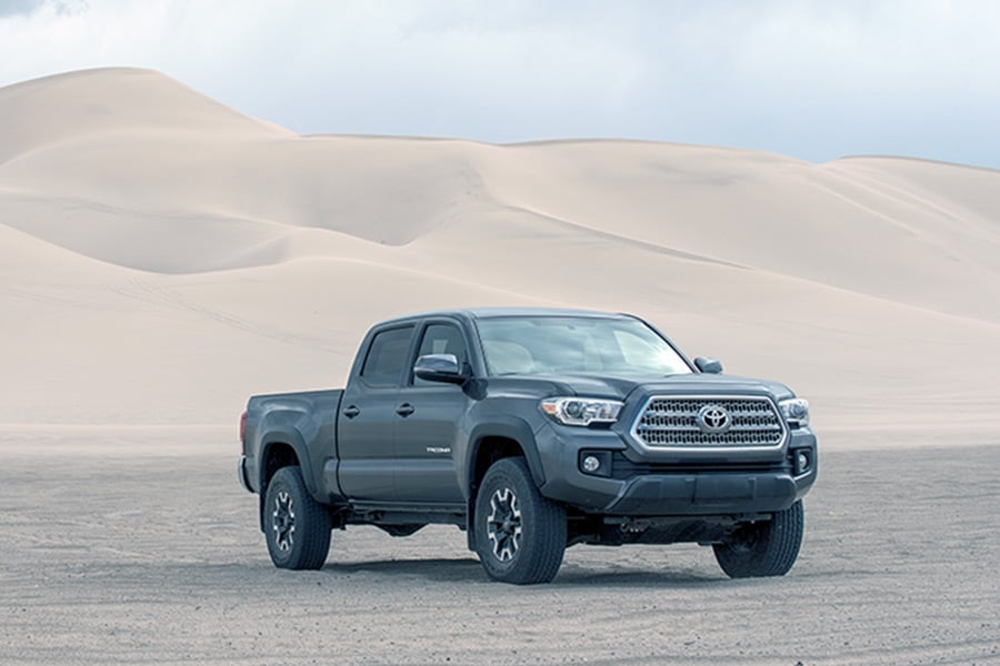 Tacoma truck in front of sand dunes
