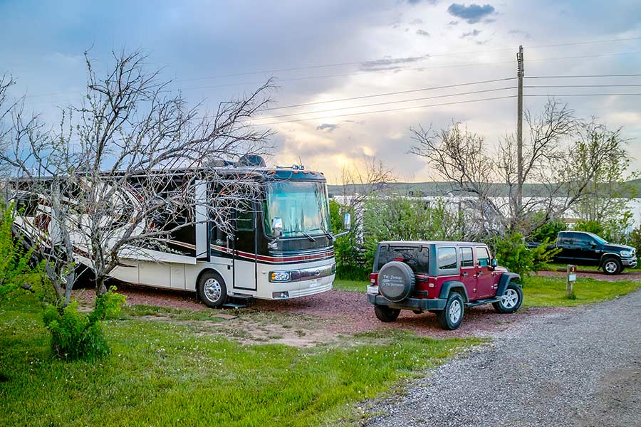 Red Jeep parked in front of a Class A RV