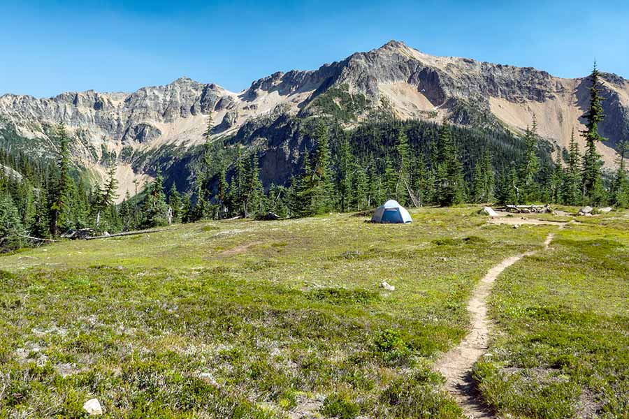 Lone tent on Pacific Crest trail, mountain in background