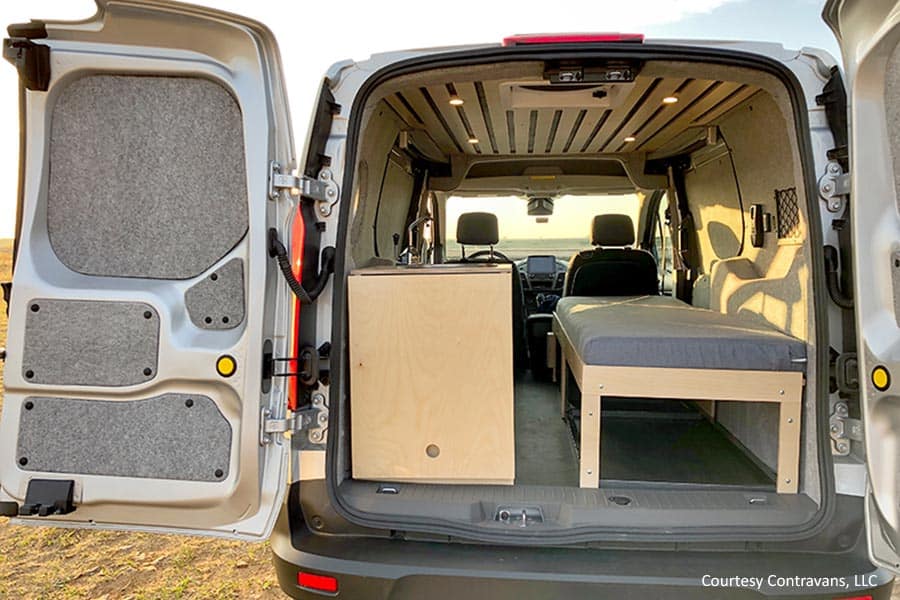 Van with rear doors open showing sink and bed