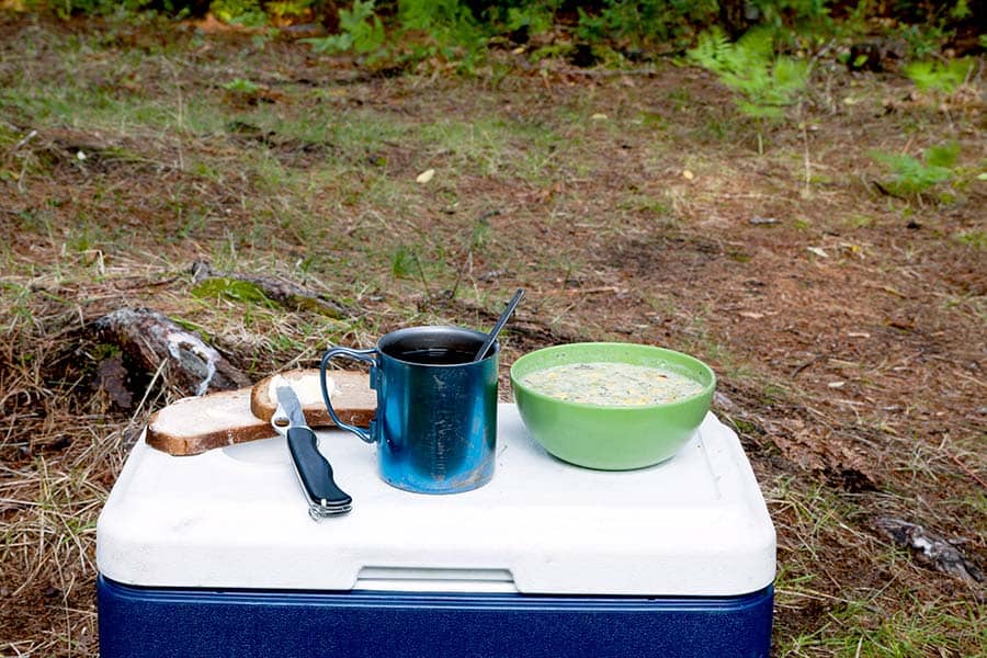 Breakfast oatmeal, coffee, and bread on top on cooler 