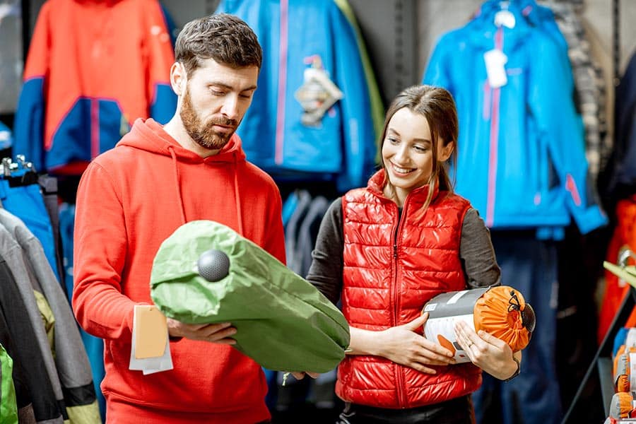 Couple buying sleeping bag for camping trip