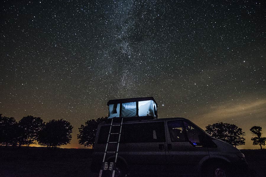 Camper van parked for the night, Milky Way stars overhead