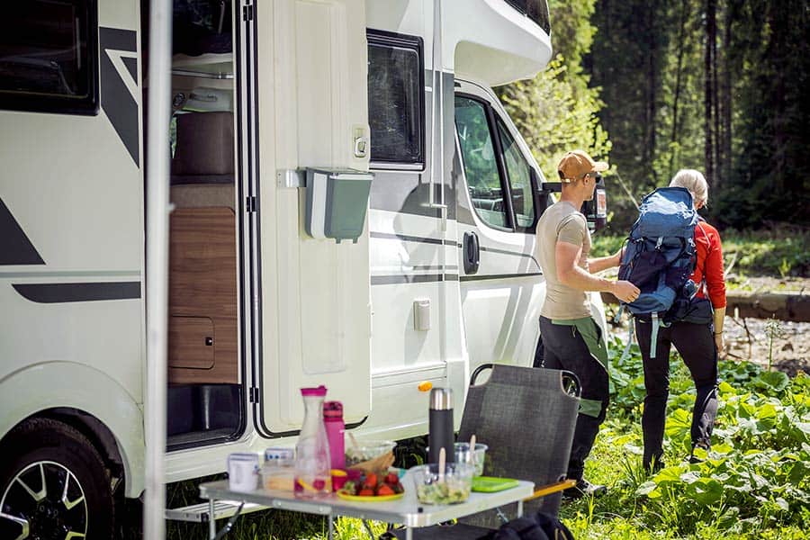 Couple preparing to leave RV for backpacking trek