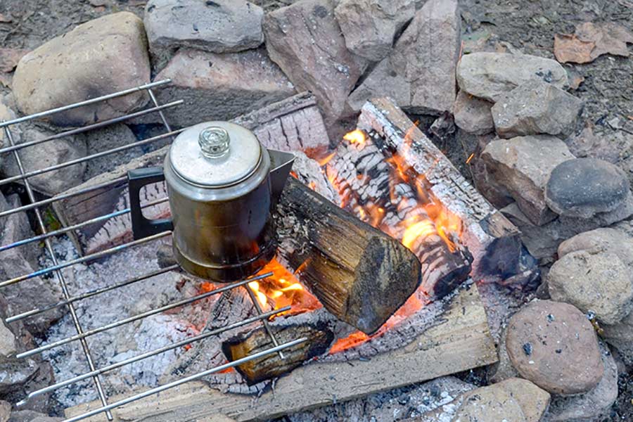 Brewing a pot of coffee over campfire