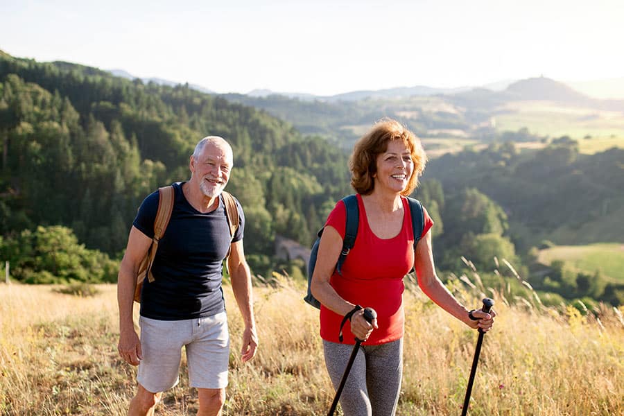 Couple hiking up mountain on nice day