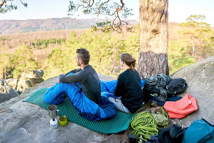 Couple sitting on rock overlooking valley