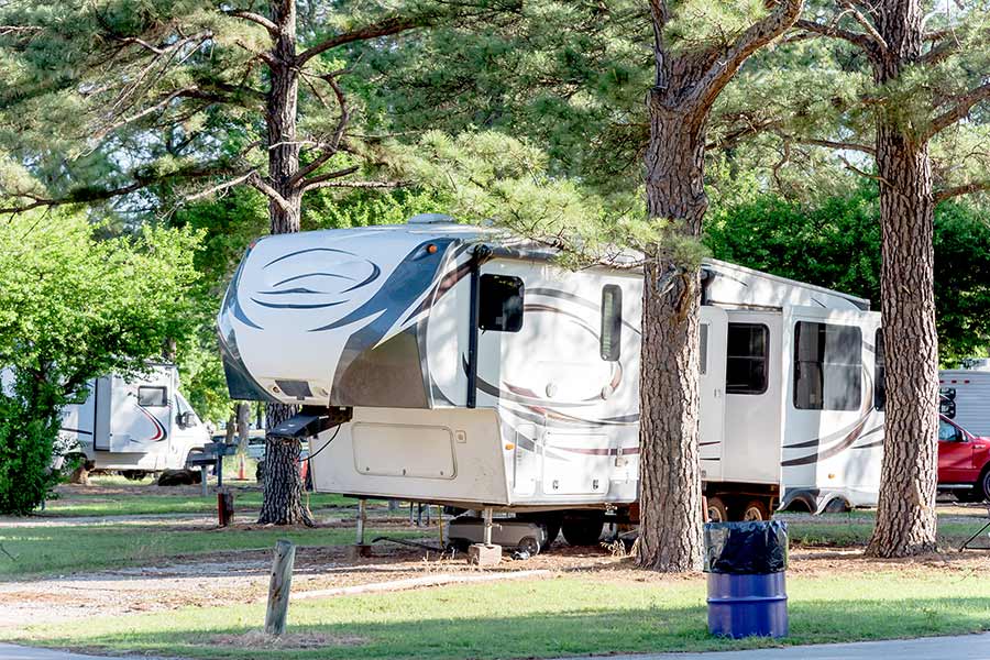 Fifth wheel camper at campground under trees