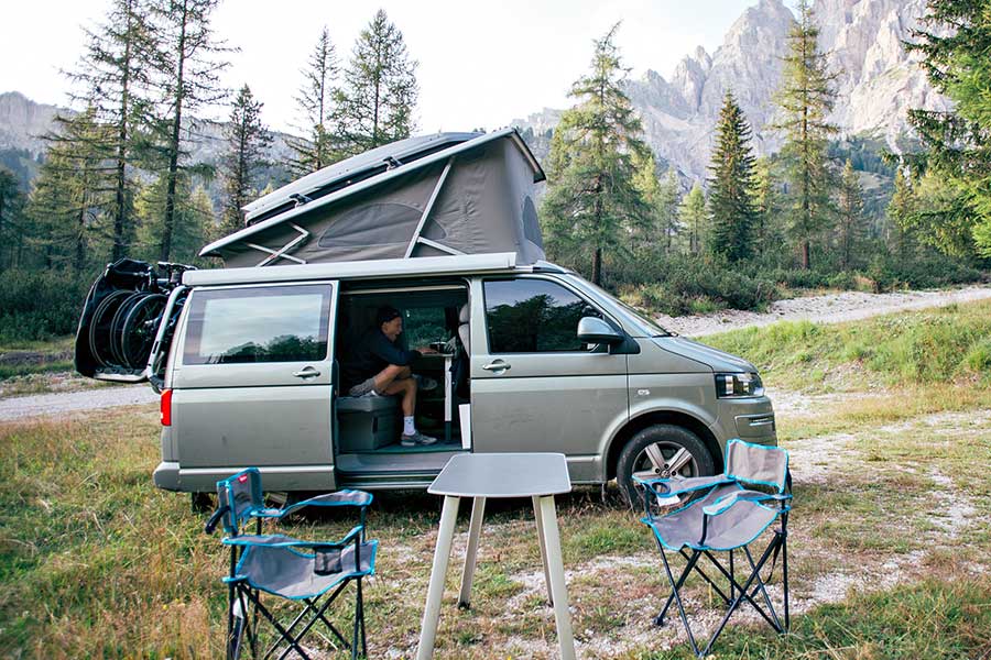 Gray pop top camper van parked in meadow
