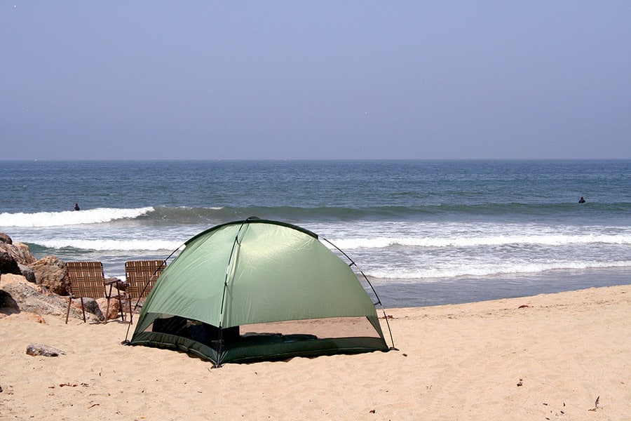 Green tent pitched on beach