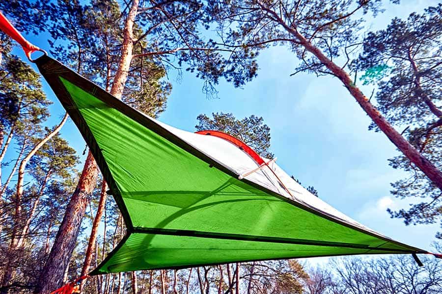 Camping tent suspended between trees
