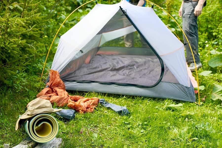 Setting up a tent in forest meadow