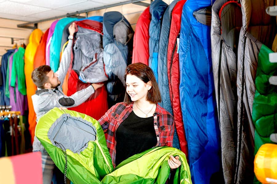 Couple looking at sleeping bags at store