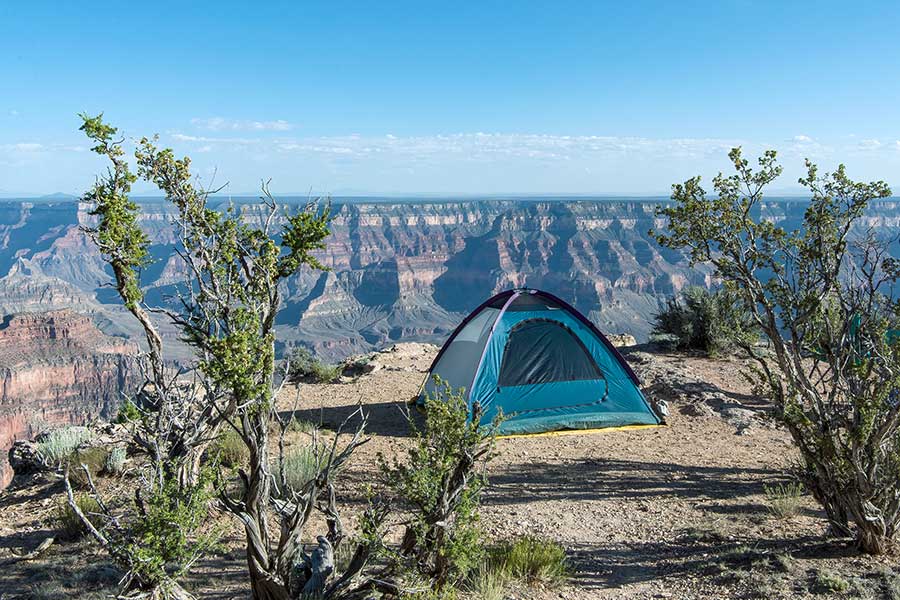 Blue tent pitched on the edge of the Grand Canyon, Arizona