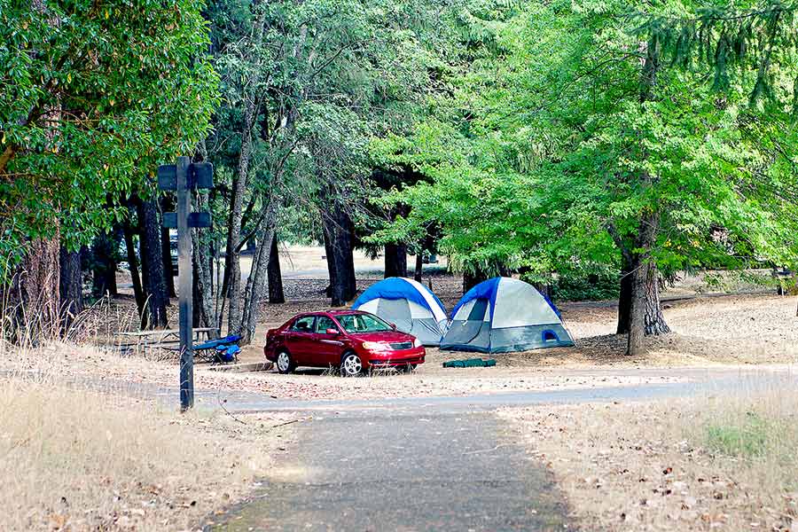 Red car and two tents at campground