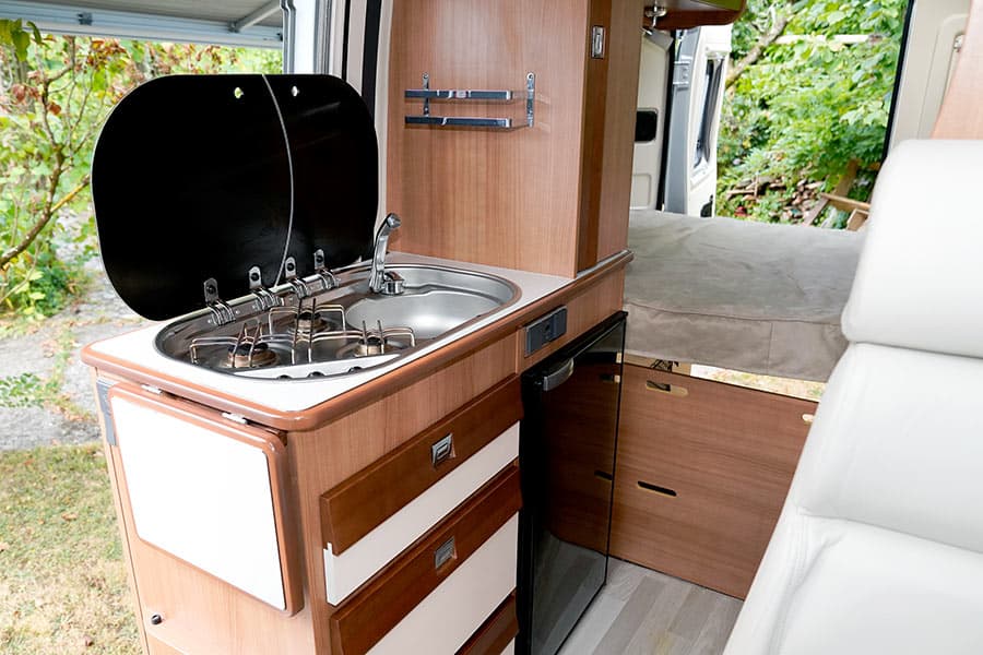 Camper van kitchenette with sink and cookstove