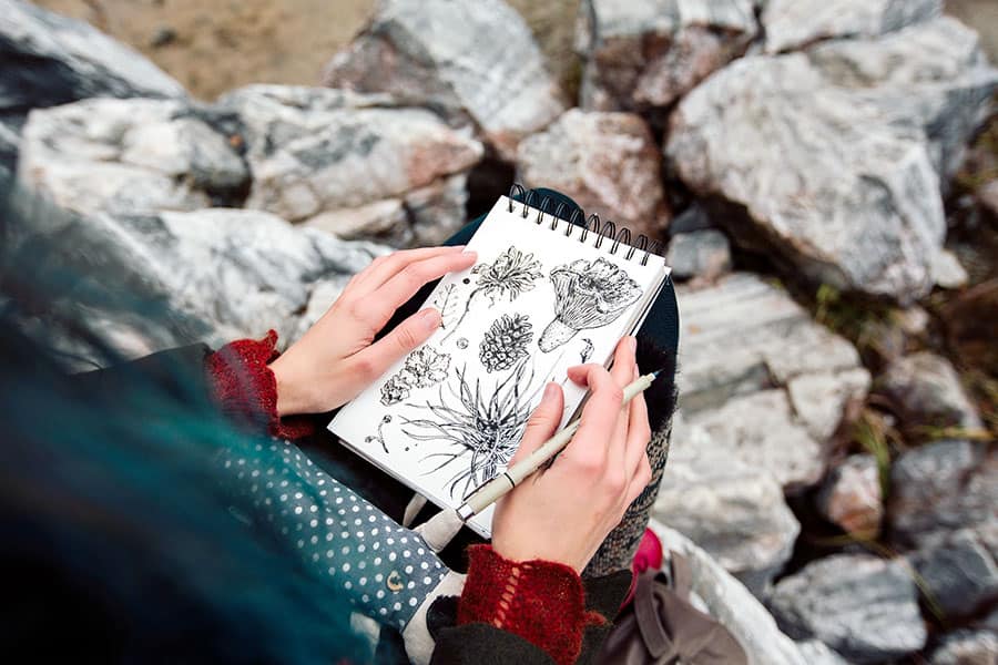 Woman drawing plants and flowers on tablet