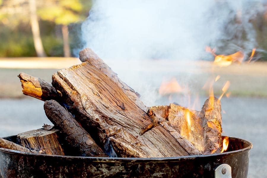 Burning wood in fire ring causing smoke