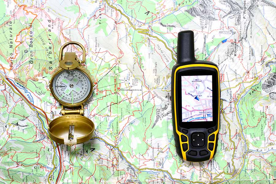 Compass and GPS laying on map