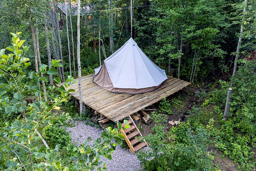 Glamping tent on wooden platform in the forest